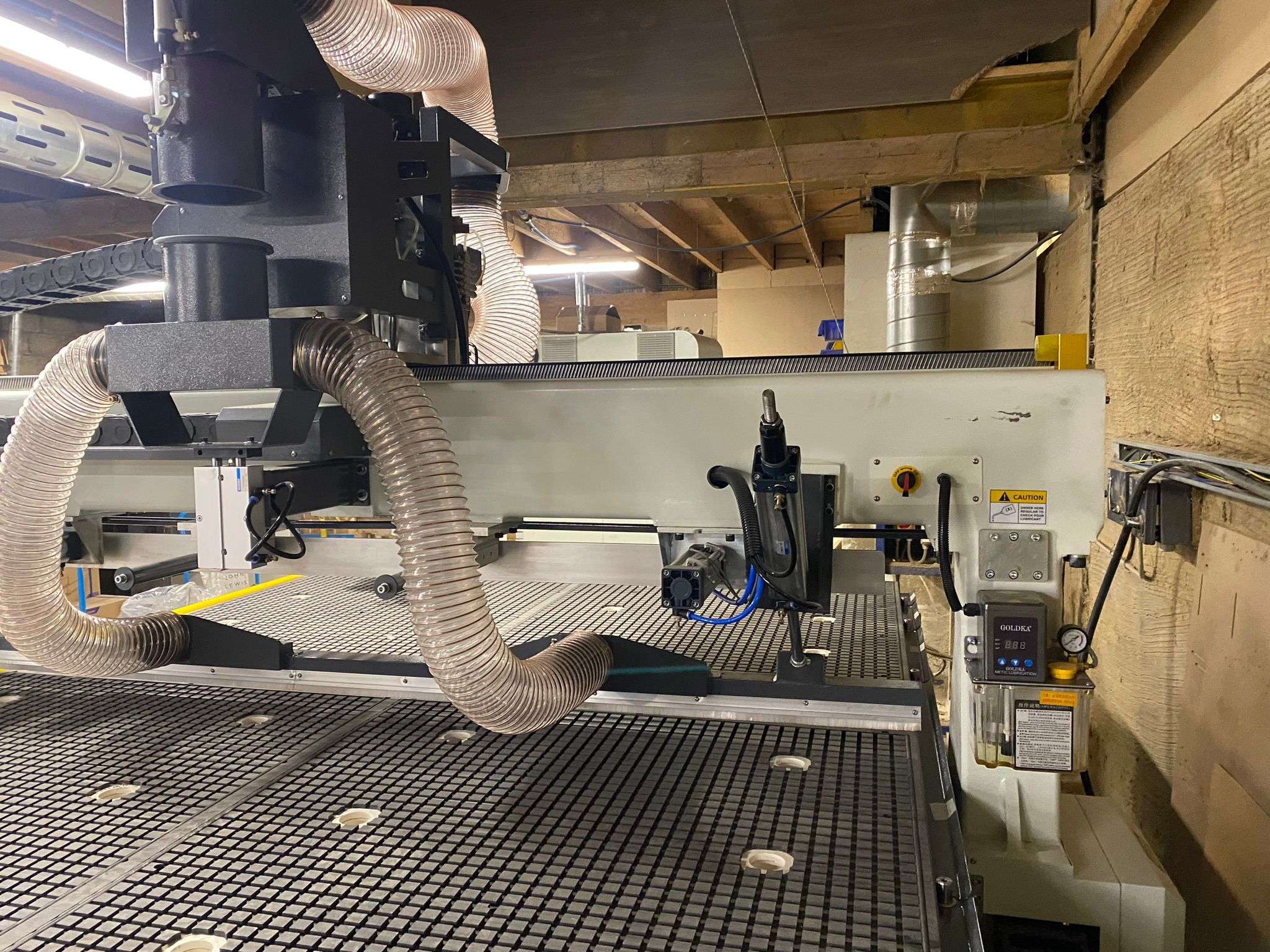 High-performance CNC router with vacuum table and dust extraction system operating in UK manufacturing facility
